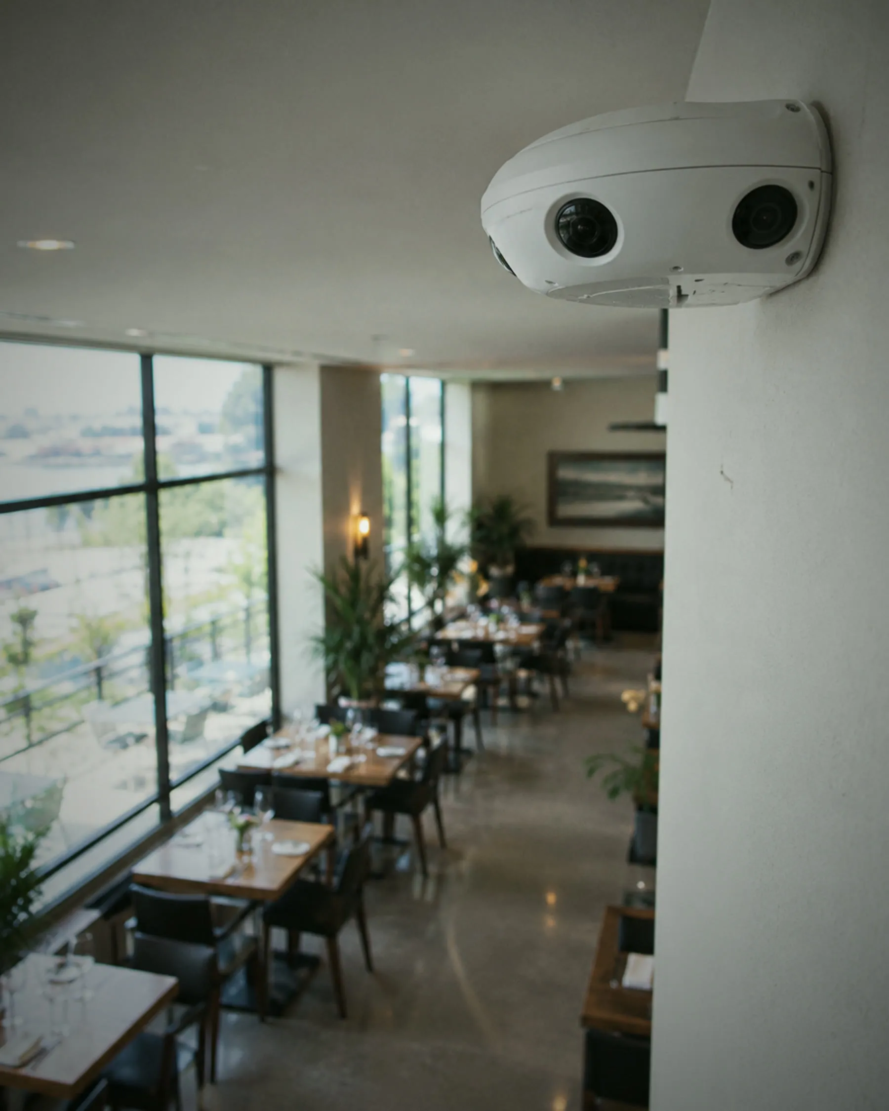 Panoramic camera on the ceiling of a restaurant dining room with street windows