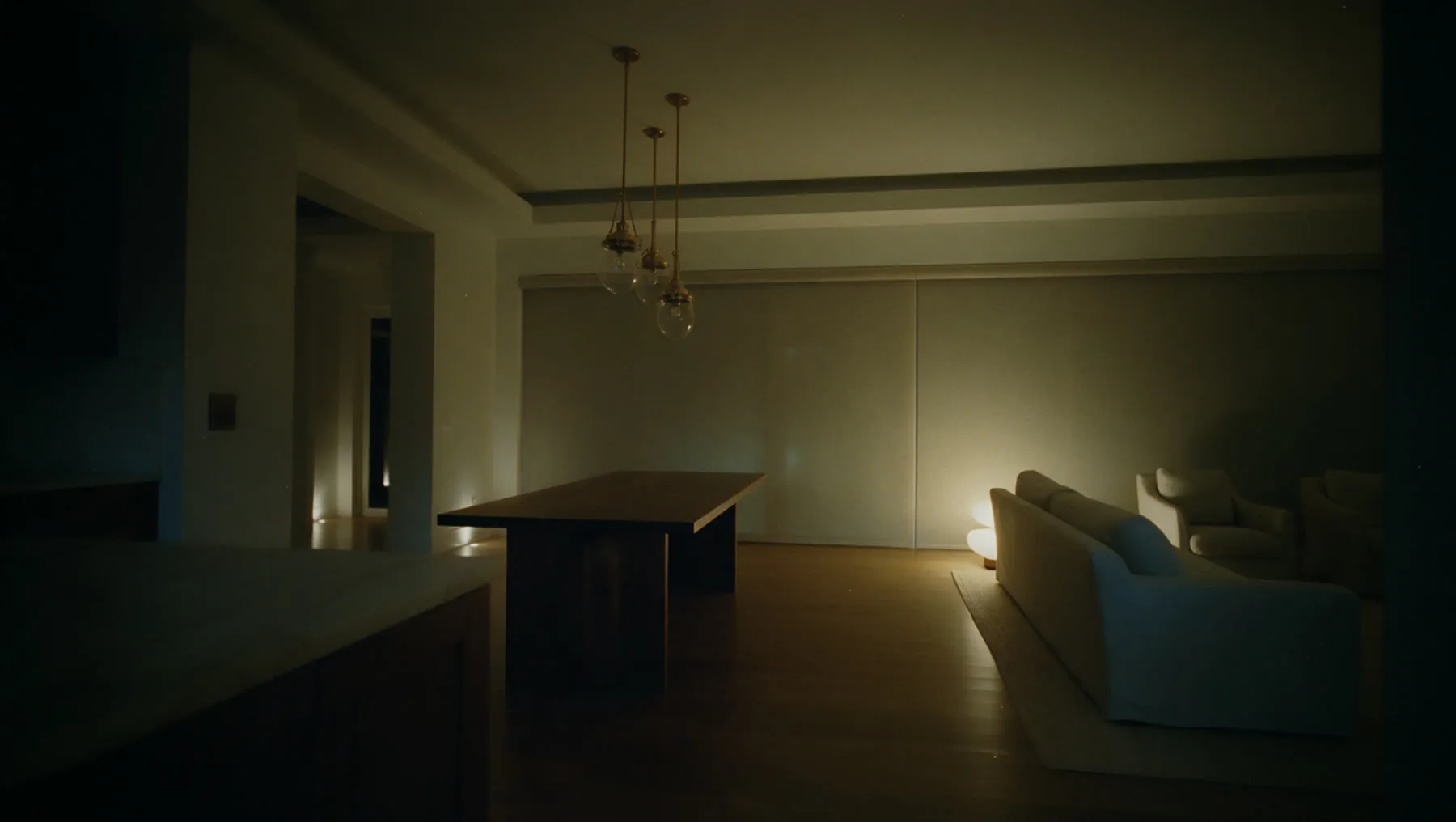 Gulf Coast great room, Notte scene at 22:45: Shades close, pendants and cove go dark, footlights along the hall hold at 5%. Doors lock and the cameras arm.
